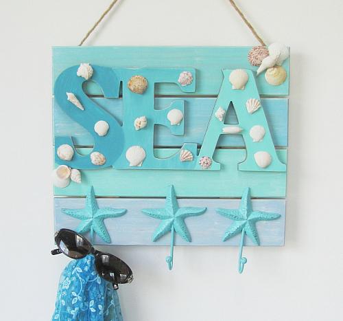 A wooden pallet sign that says sea on it in a blue ombre.
