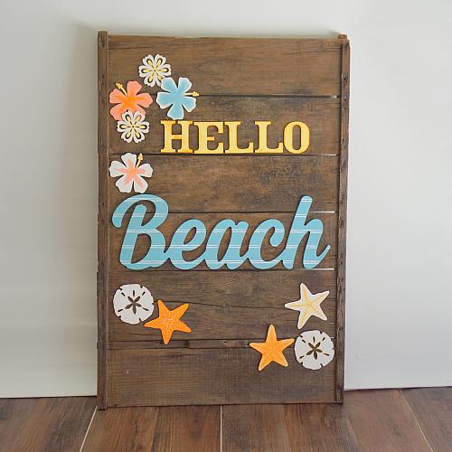 A wooden sign says hello beach