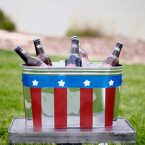 A tin cooler painted with the stars and stripes and filled with beers