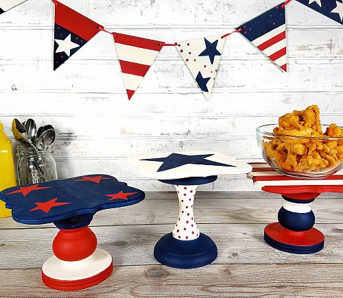 Patriotic table stands for a 4th of July party with bowls of party snacks on top