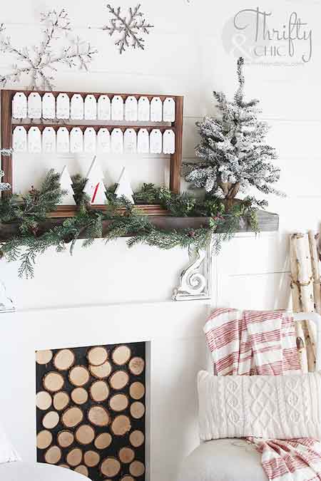 A white advent calendar on a wood rack above a fireplace