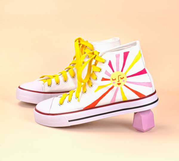 White converse high tops with a retro sunset painted on them.
