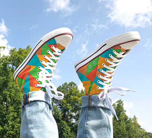 High top converse with a geometric pattern painted on them.