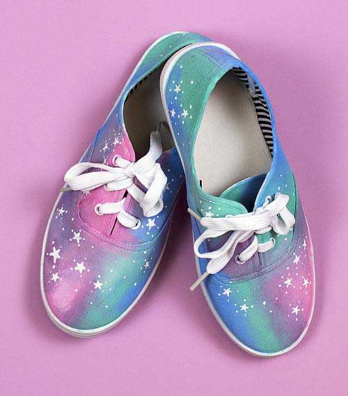 Tennis shoes with a pastel galaxy print painted onto them.