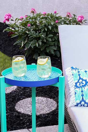 An outdoor end table is painted blue and teal