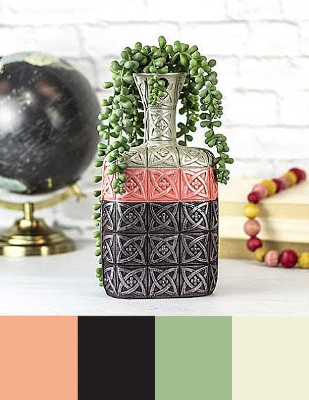 An ornate vase is painted in a color block design using metallic gray, jet black, and soft coral.