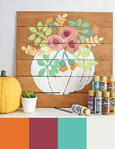A painting of a white pumpkin with colorful flowers painted on the top. A color palette features orange, burgundy, teal, and white.