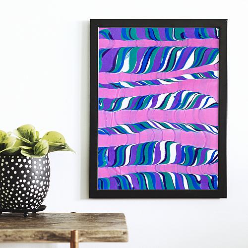 A framed water marbling paper in cool colors that looks almost like a forest of trees