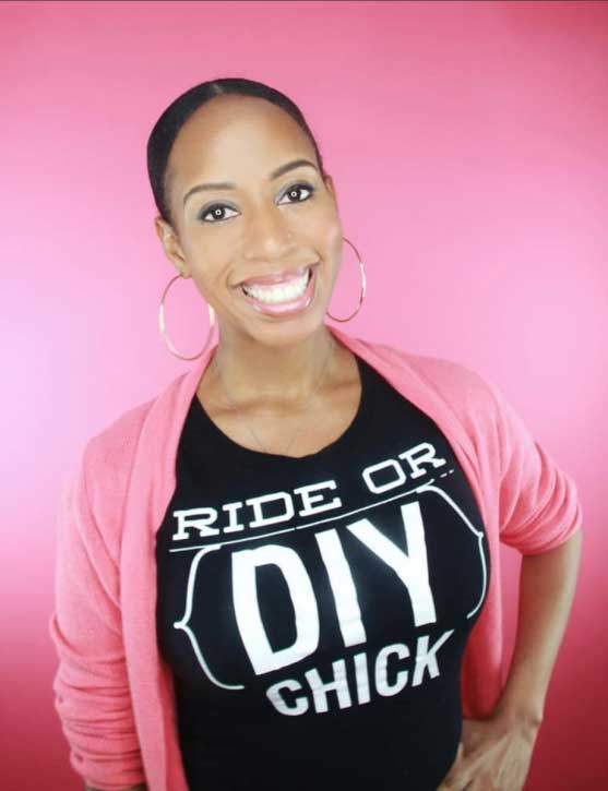 DIY blogger A.V. Perkins faces the camera with a big smile against a pink background, her shirt says ride or DIY chick
