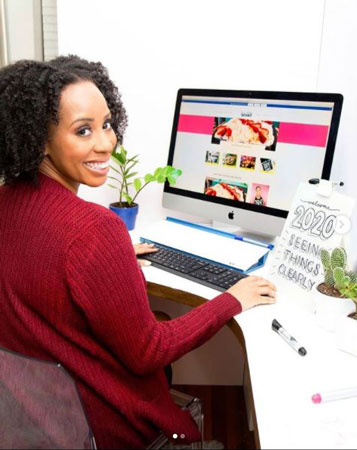 DIY blogger A.V. Perkins sits at her computer editing another blog entry and smiling happily.