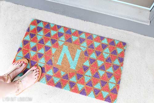 A doormat is painted in a geometric pattern using acrylic paint.