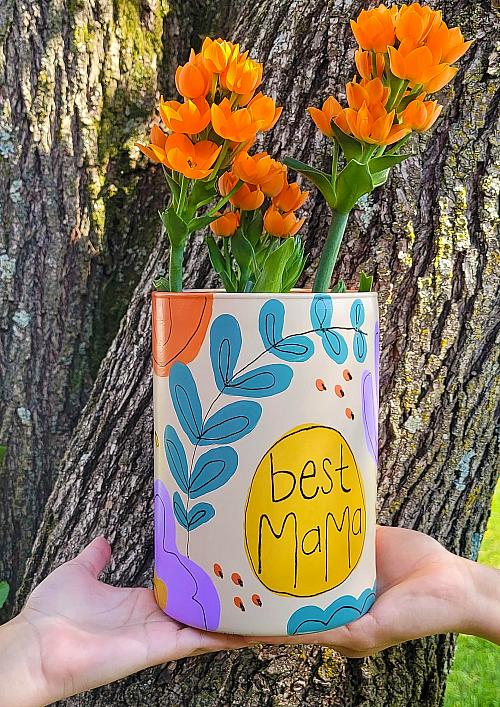 A mother's day vase filled with orange flowers