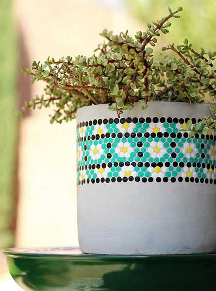 A concrete planter is painted using dots of acrylic paint to look like a penny tile pattern.
