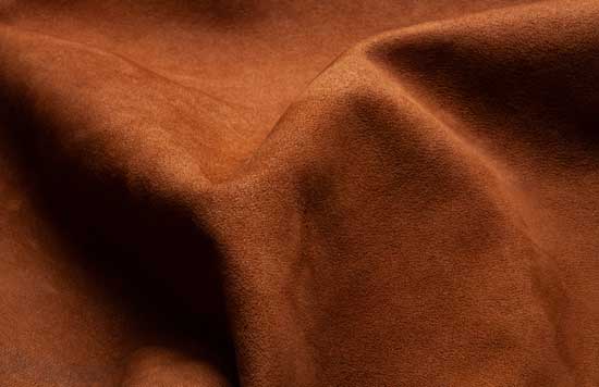 A close-up look at rumpled suede fabric in a brown-red shade