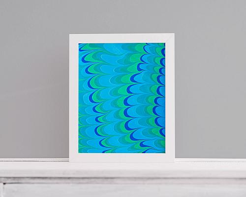 A framed water marbling print in ocean colors with the arches pattern.