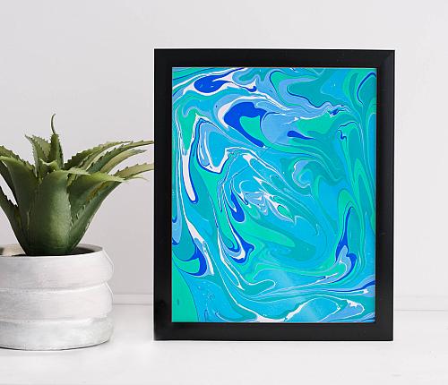 A framed water marbling print in swirling blue