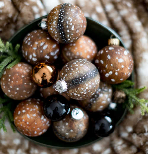 Ornaments painted like deer fur sit in a bowl