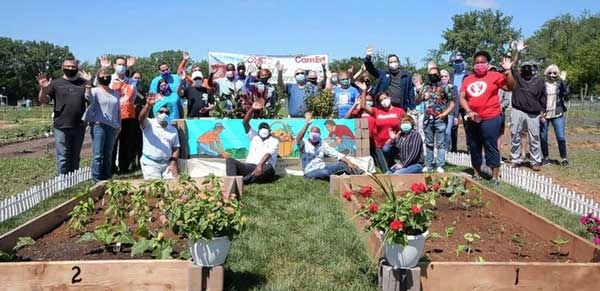 A group photo of OLI members in front of garden beds.