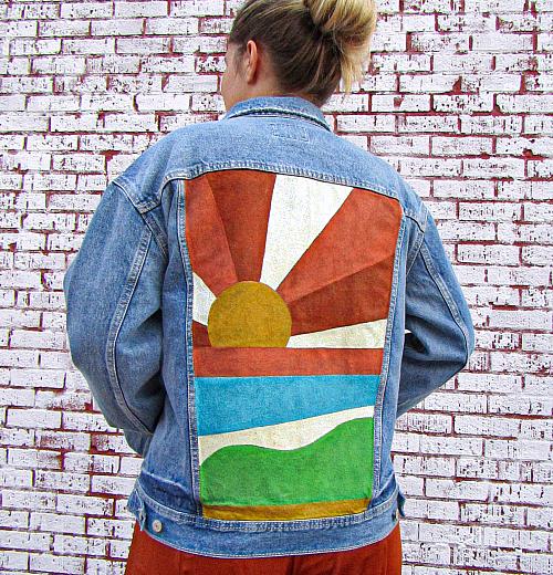 A jean jacket with the back painted to look like a retro 70's sunset.