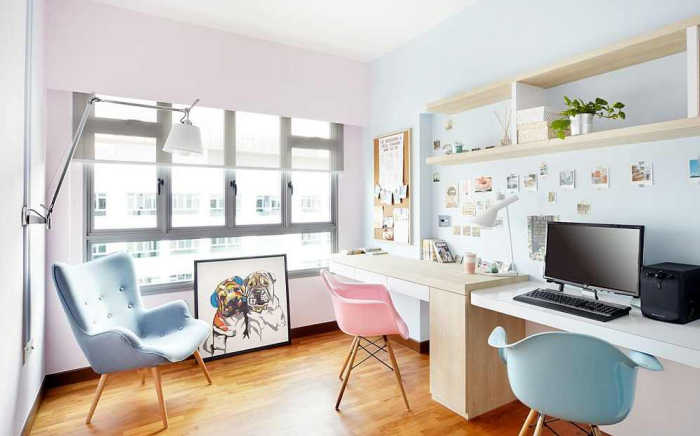 A home office with pastel blue chairs and pink accents