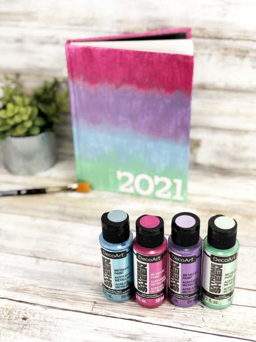 A journal cover painted in a metallic rainbow using DecoArt Extreme Sheen