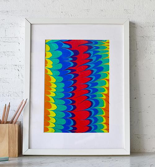 A framed water marbling paper in a rainbow arches pattern
