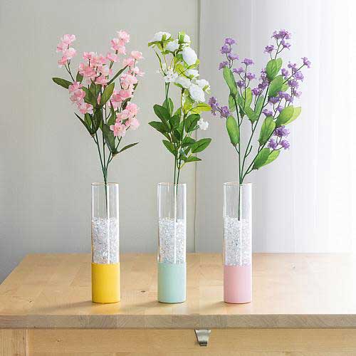 Three tall and thin glass vases are dipped halfway in pastel acrylic paint for a cute spring look