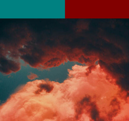 A photo of a dramatic sunset featuring teal and maroon colors