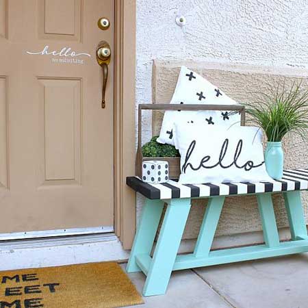 A teal bench with a pillow that says 