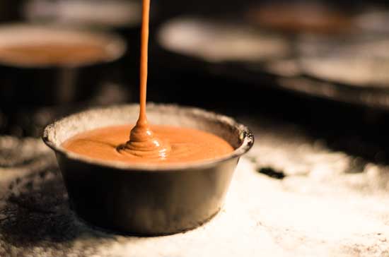 Caramel drizzling down into a stone bowl