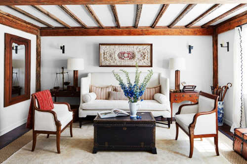 A warm white room with natural wood beams