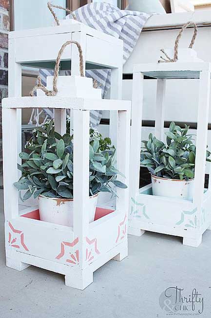 Oversized wooden lanterns are painted and placed outside for a beautiful decoration.